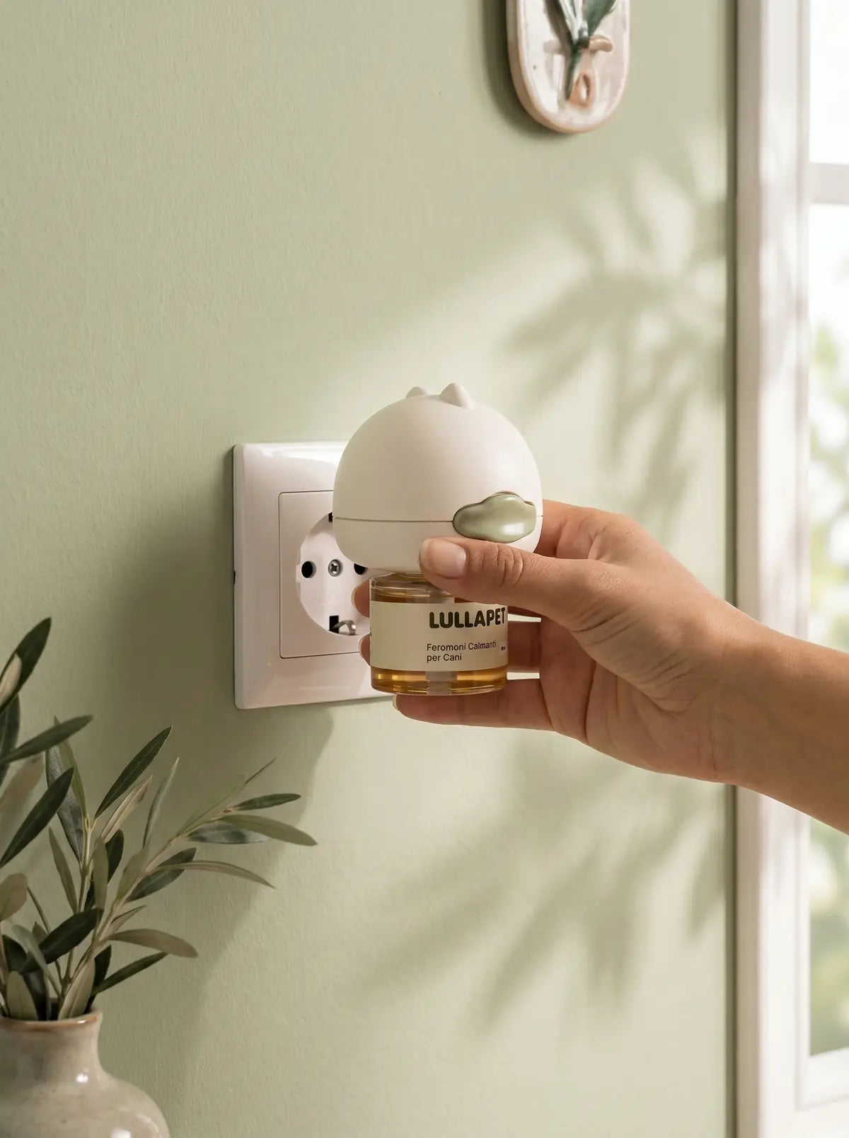 Mano che inserisce il diffusore Lullapet in una presa elettrica italiana